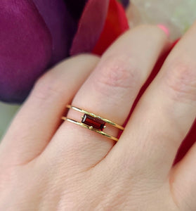 sophisticated 14k yellow gold ring featuring emerald cut garnet