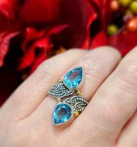 18k yellow gold and sterling silver ring swirled with sparkling blue topaz