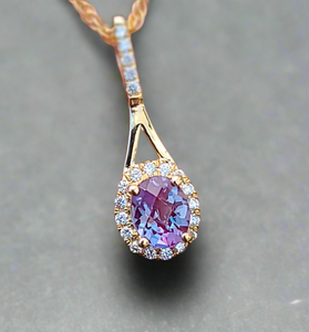 mesmerizing alexandrite gemstone pendent accented by small diamonds and 14k gold surrounding 