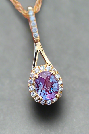 mesmerizing alexandrite gemstone pendent accented by small diamonds and 14k gold surrounding 