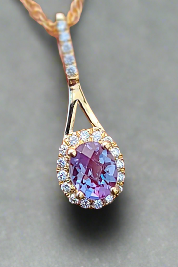 mesmerizing alexandrite gemstone pendent accented by small diamonds and 14k gold surrounding 