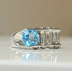 Sterling silver ring with oval blue topaz and baguette diamond accents