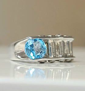 Sterling silver ring with oval blue topaz and baguette diamond accents