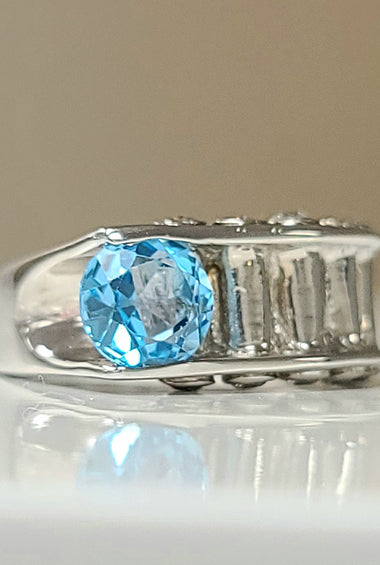 Sterling silver ring with oval blue topaz and baguette diamond accents
