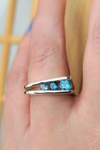 Sterling silver 3-stone corner ring with three blue gemstones on a slim band