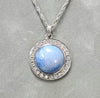Sterling silver pendant with round blue dyed agate center and crystal halo bezel