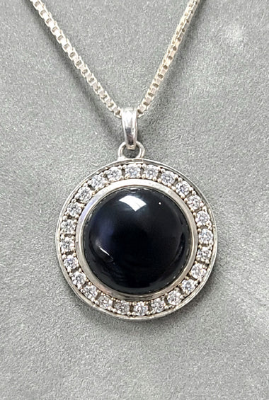 Sterling silver onyx pendant with round black cabochon and crystal halo