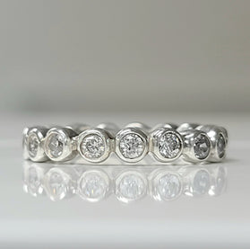 Sterling silver eternity ring with round white topaz stones across the band