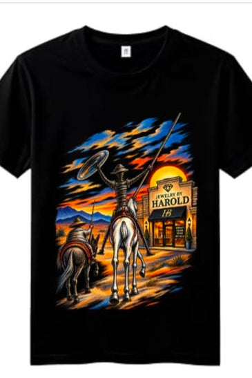 A black short-sleeve crewneck t-shirt featuring a large graphic print on the front. The graphic depicts a cowboy on a white horse holding a lasso in front of a saloon sign that reads 'JEWELRY OF HAROLD 1919', with a dark horse and a dramatic sunset sky in the background.