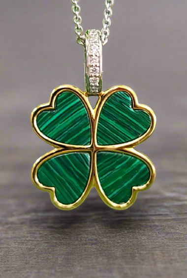 Four-leaf clover pendant with green malachite set, gold-tone frame on silver chain