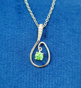 White gold teardrop pendant with peridot and diamond accents on a chain