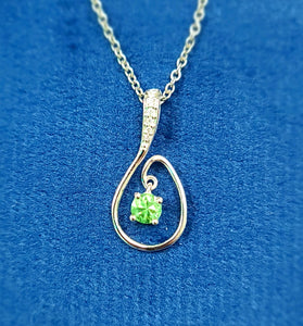 vibrant green peridot surrounded by diamonds with 14k white gold