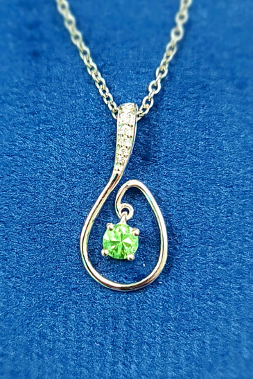 vibrant green peridot surrounded by diamonds with 14k white gold