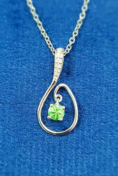 vibrant green peridot surrounded by diamonds with 14k white gold