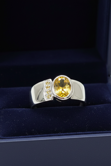 Sterling silver yellow citrine bezel ring displayed inside an open dark blue velvet jewelry gift box