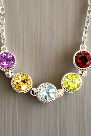Sterling silver chain necklace with five bezel-set round gems: purple, yellow, blue, lime, red