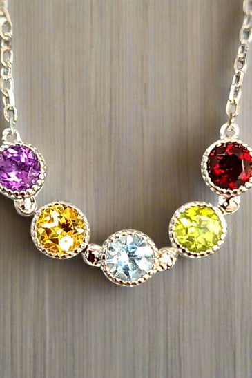 Sterling silver chain necklace with five bezel-set round gems: purple, yellow, blue, lime, red