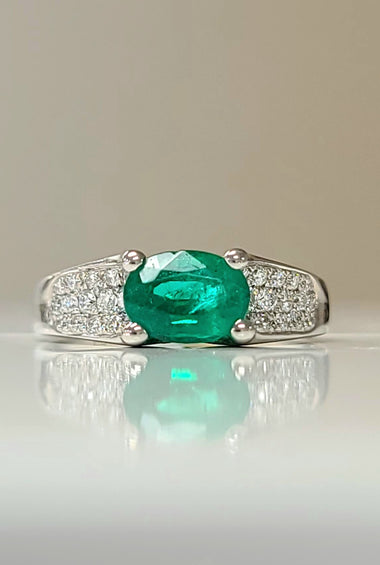 White gold emerald and diamond ring with oval green gemstone center, pavé diamond band