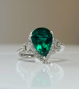 White gold ring with oval green lab emerald center and diamond halo, prong-set
