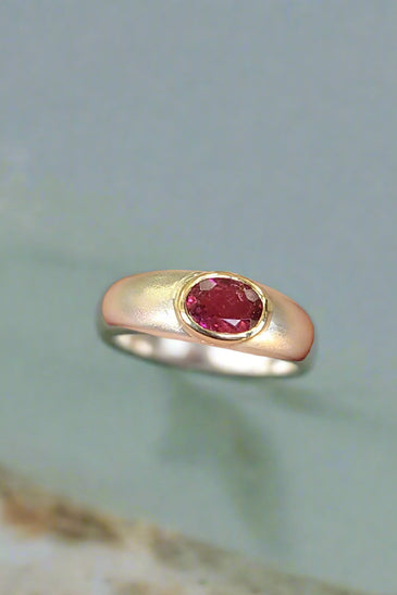 bold pink tourmaline stone set in a 14k yellow gold bezel and band
