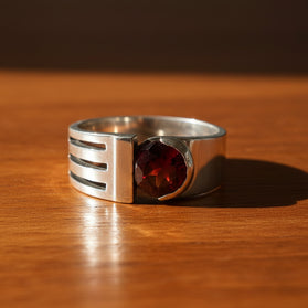 Sterling silver garnet ring with red gemstone and negative-space band detail