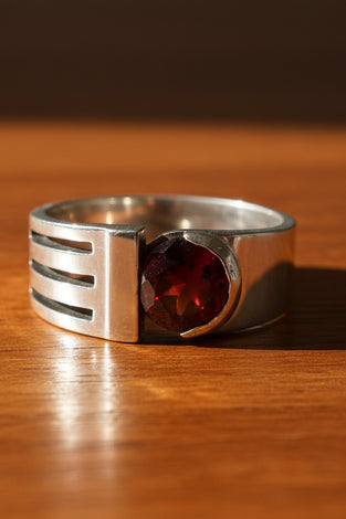 Sterling silver garnet ring with red gemstone and negative-space band detail