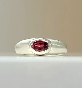 rose gold rhodolite garnet gemstone surrounded by sterling silver