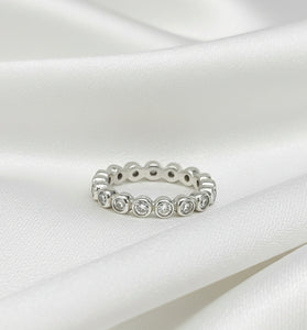 Sterling silver eternity ring with round white topaz stones in bezel settings