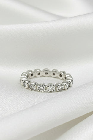 Sterling silver eternity ring with round white topaz stones in bezel settings