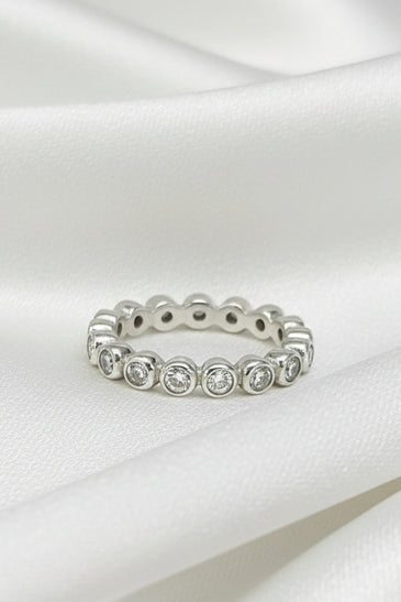 Sterling silver eternity ring with round white topaz stones in bezel settings