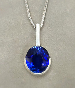 Sterling silver pendant with oval blue lab sapphire, half bezel, on chain