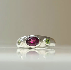 Sterling silver bezel ring with oval purple center and two green side stones