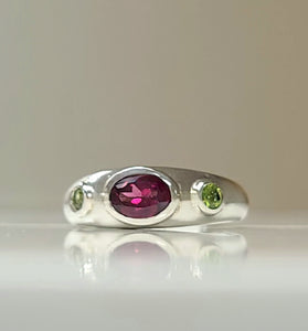 Sterling silver bezel ring with oval purple center and two green side stones