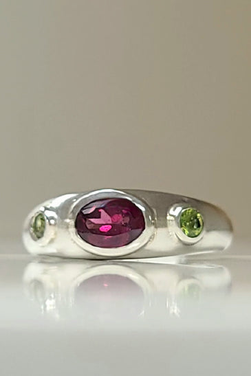 Sterling silver bezel ring with oval purple center and two green side stones