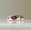 Sterling silver bezel ring with oval purple center and two green side stones