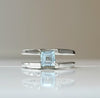 Sterling silver ring with square blue topaz centerpiece, open bypass design