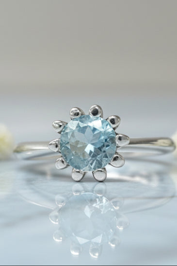 Sterling silver tulip ring with round blue topaz center and petal prongs