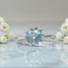 Sterling silver tulip ring with round blue topaz center and petal prongs