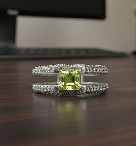 Sterling silver ring with green peridot center and sparkling side stones, V design
