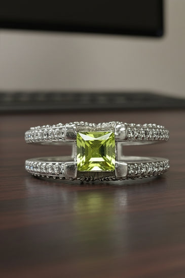 Sterling silver ring with green peridot center and sparkling side stones, V design