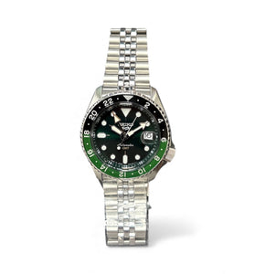 Stainless steel wristwatch with black dial, green bezel, and metal bracelet