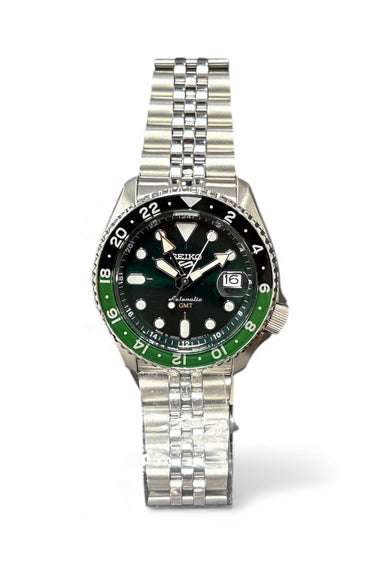 Stainless steel wristwatch with black dial, green bezel, and metal bracelet