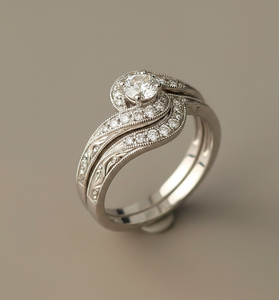 Close-up of a 14kt white gold vintage-style diamond wedding set showing the curved halo, split prongs, and milgrain swirl detail