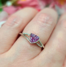 Alexandrite ring in white gold with purple oval gemstone and small green accents