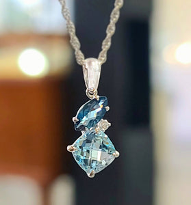 14k white gold pendent featuring diamonds and london blue topaz