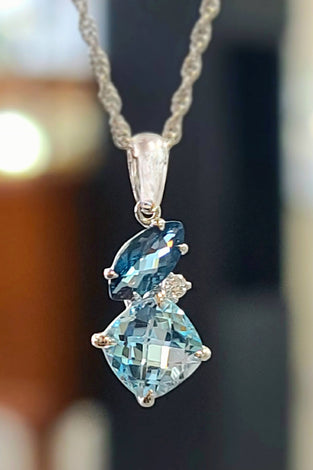 14k white gold pendent featuring diamonds and london blue topaz