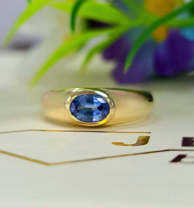 Yellow gold bezel-set sapphire ring with oval blue gemstone