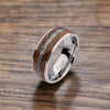 Stainless steel ring with wood and dark inlay, polished interior, angled view