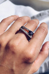 Woman Wearing an asymmetrical ring, displaying a rich garnet stone on the outer edge of a sterling silver ring