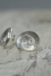 Diamonds are dusted throughout the scratch matte sterling silver forming the swirled studs